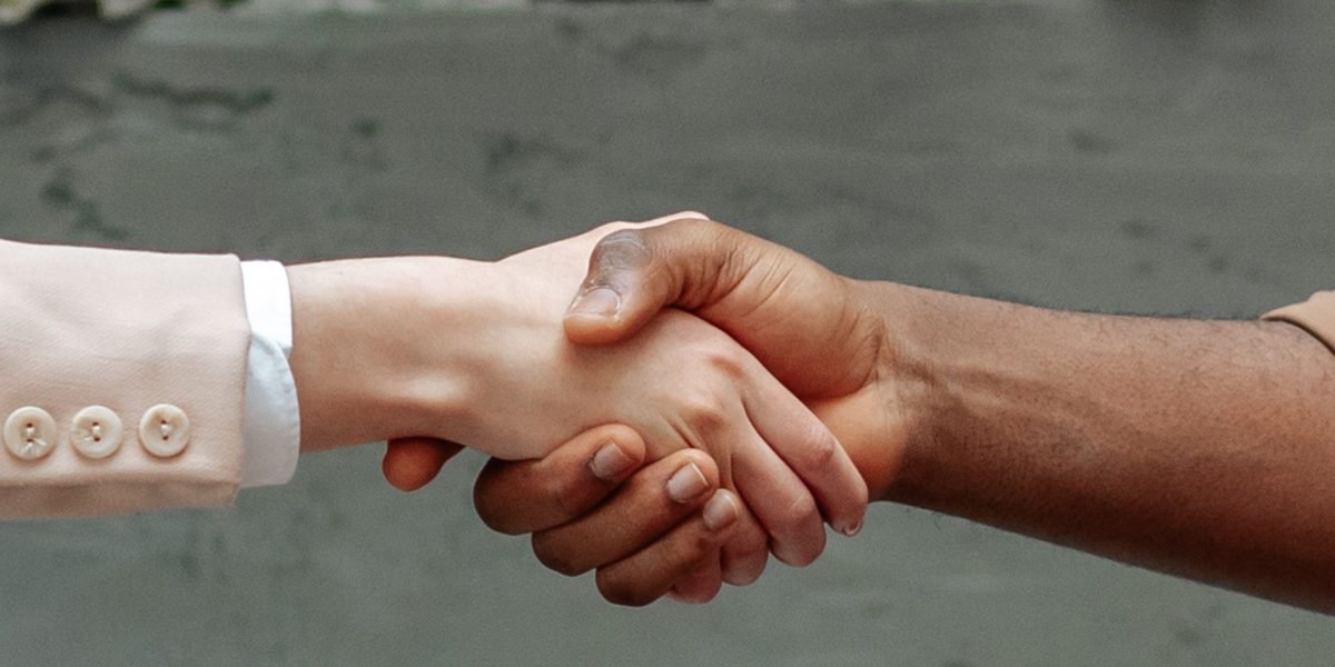 Two business partners shaking hands firmly, symbolizing the establishment of a trusted, long-term working relationship.