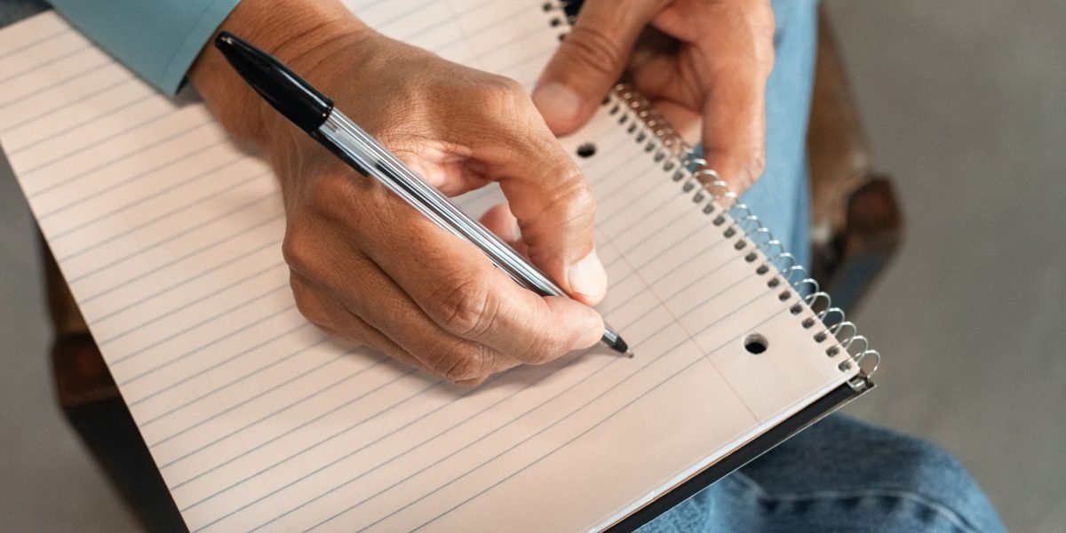 A person carefully comparing different options on paper or a tablet, symbolizing the selection process.