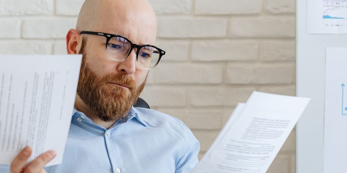 An investor carefully reviewing documents to make informed decisions about their financial future.