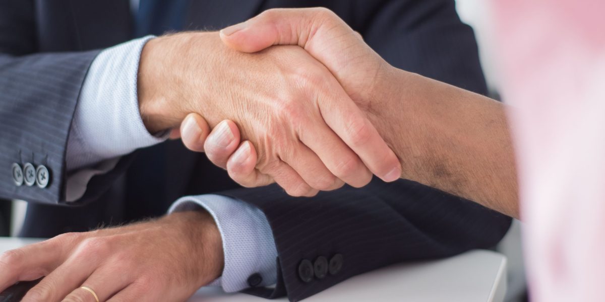 Professionals shaking hands, symbolizing trust, agreement, and successful collaboration in a business context.