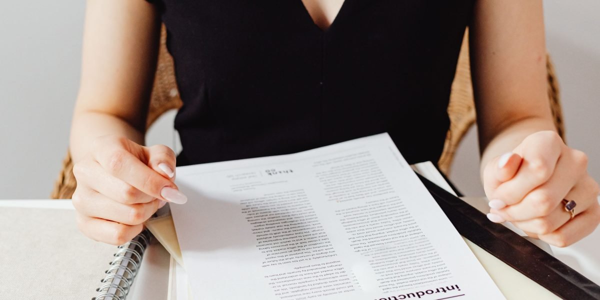 A person intently reviewing documents in a coffee shop, representing detailed financial planning.