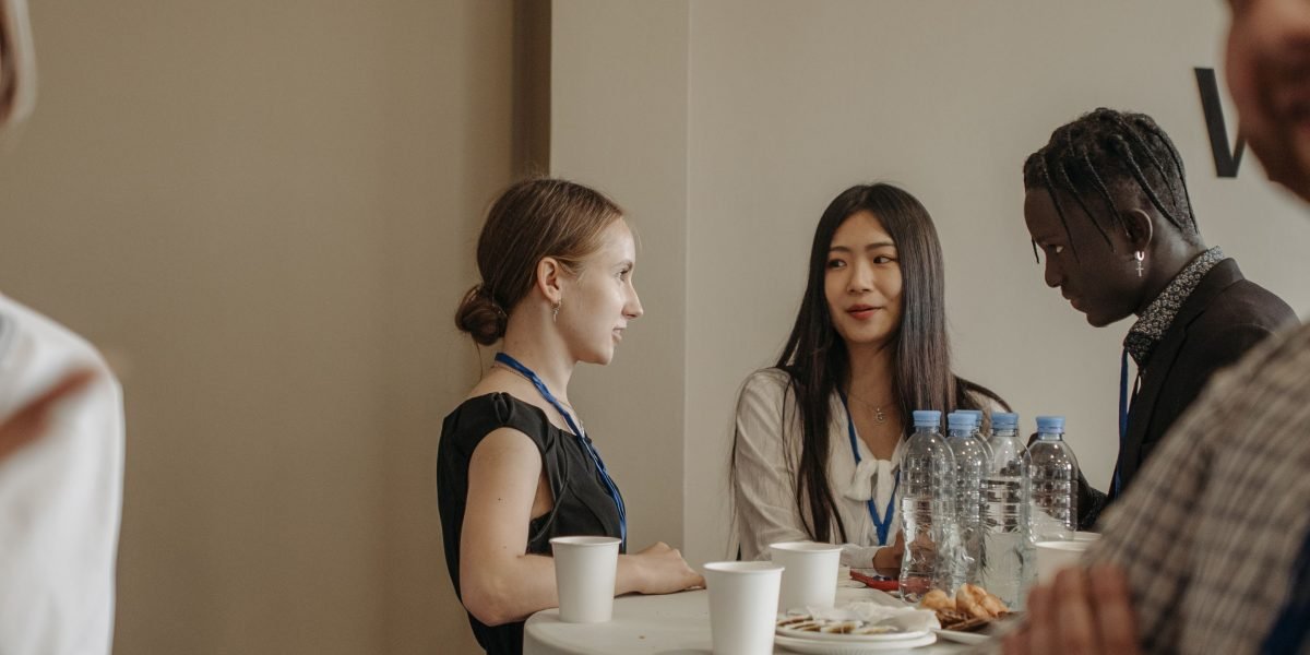 Individuals networking at a professional event, discussing referrals for financial advisors.